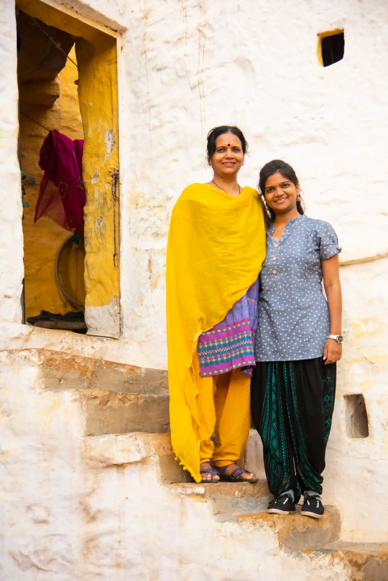 Image of two Indian women standing on a stair.