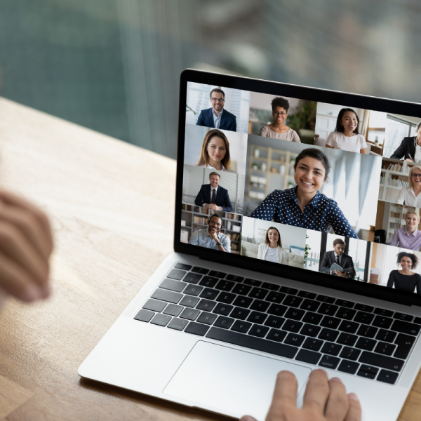 A computer with a screen of people in a video meeting.